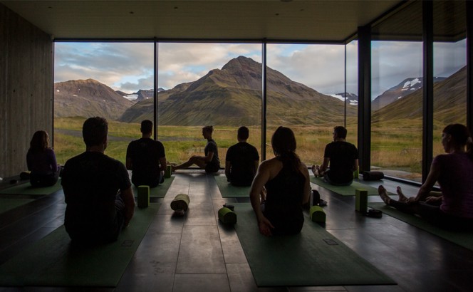 Group of people in a yoga class with a view of mountains.
